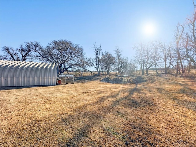 view of yard with a rural view and an outbuilding