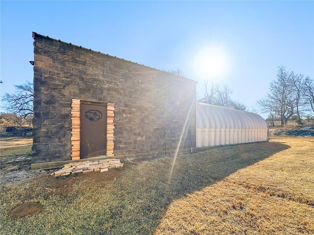 view of front of house with an outdoor structure and a front yard