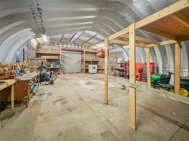 misc room featuring lofted ceiling, concrete flooring, and a workshop area