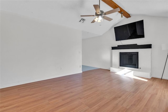 unfurnished living room featuring lofted ceiling with beams, ceiling fan, and light wood-type flooring