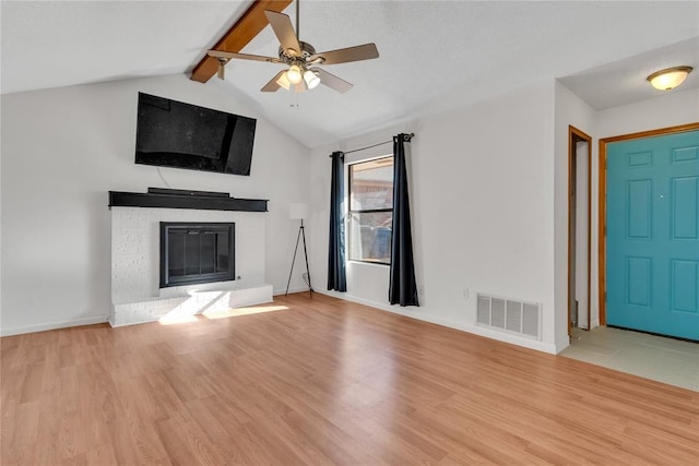 unfurnished living room with vaulted ceiling with beams, a fireplace, light hardwood / wood-style floors, and ceiling fan