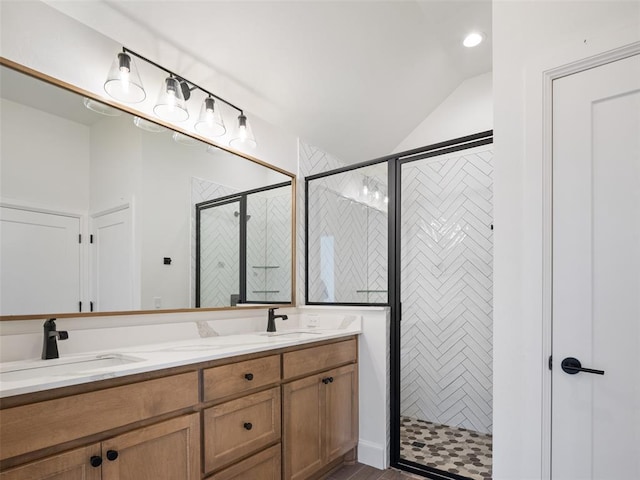 bathroom with vanity, a shower with shower door, and lofted ceiling