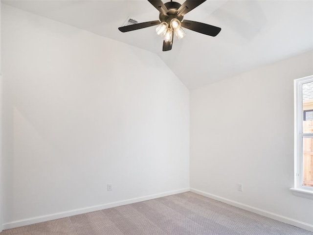 carpeted spare room featuring ceiling fan, lofted ceiling, and a wealth of natural light