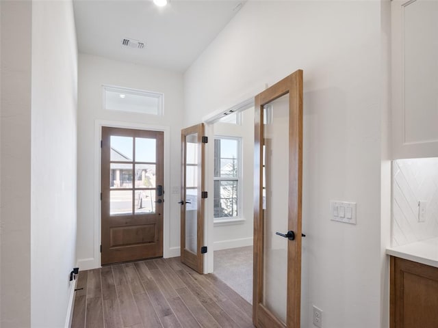 foyer entrance with french doors and light hardwood / wood-style flooring