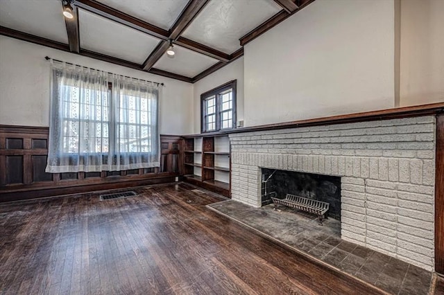 unfurnished living room featuring dark hardwood / wood-style floors, coffered ceiling, a fireplace, and beamed ceiling