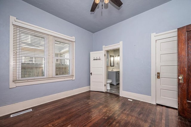 unfurnished bedroom featuring dark hardwood / wood-style floors, sink, ceiling fan, and ensuite bath