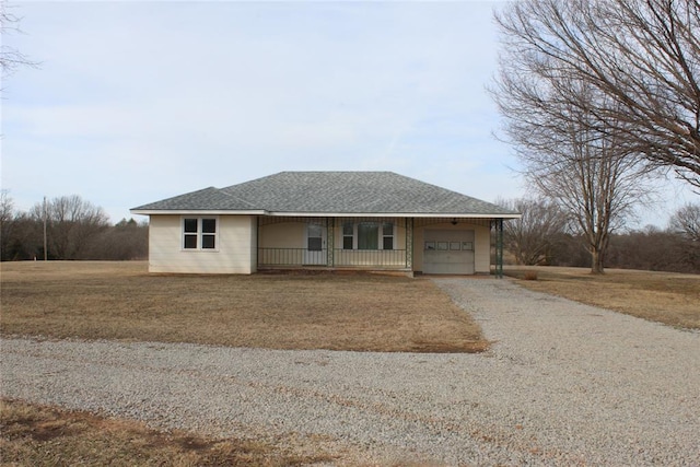 view of front of home featuring a porch, a garage, and a front yard