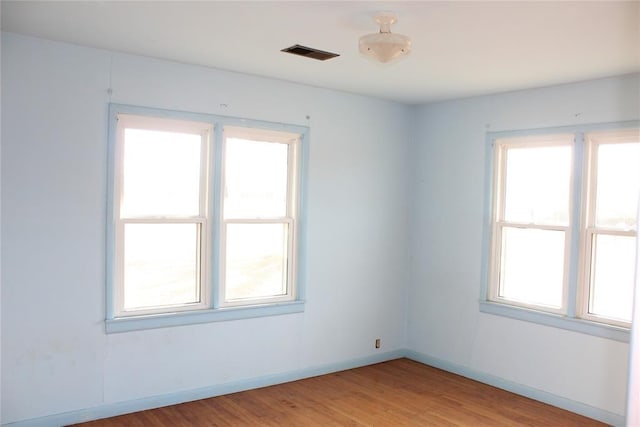 unfurnished room featuring plenty of natural light and light hardwood / wood-style flooring