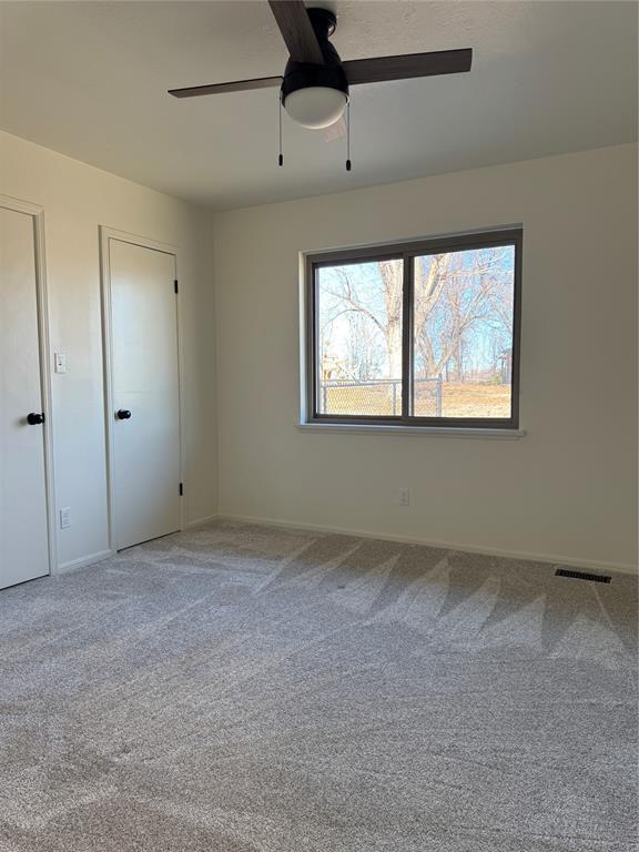 unfurnished bedroom with ceiling fan and carpet flooring