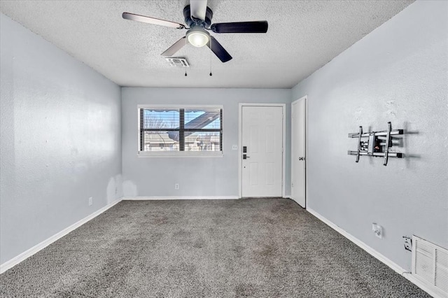 carpeted spare room with ceiling fan and a textured ceiling