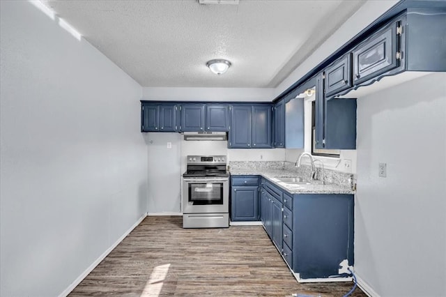 kitchen featuring sink, blue cabinetry, wood-type flooring, a textured ceiling, and stainless steel range with electric cooktop