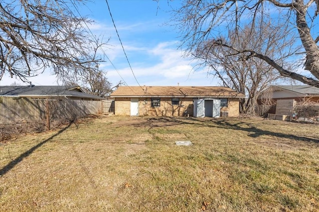 back of property featuring an outbuilding and a lawn