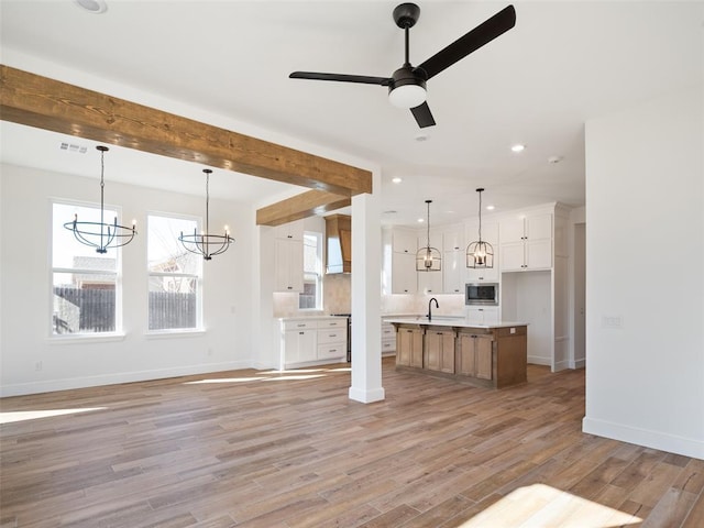 living room featuring sink, ceiling fan with notable chandelier, and light wood-type flooring