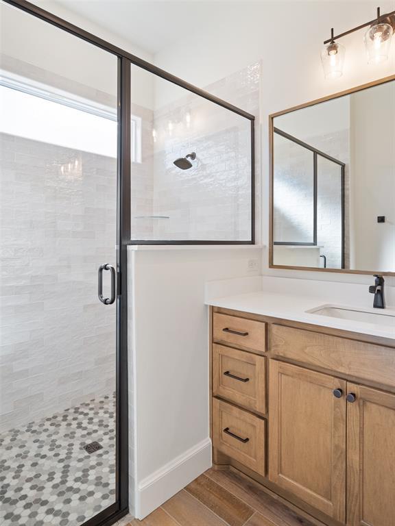 bathroom featuring hardwood / wood-style flooring, vanity, and an enclosed shower