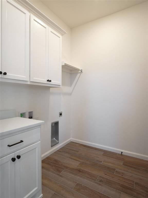 clothes washing area featuring washer hookup, electric dryer hookup, dark hardwood / wood-style floors, and cabinets