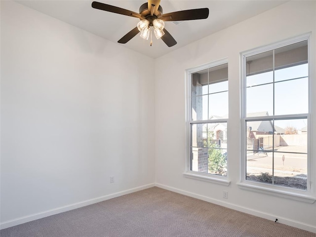 unfurnished room with ceiling fan and carpet