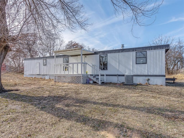 view of front of house with central AC and a front lawn