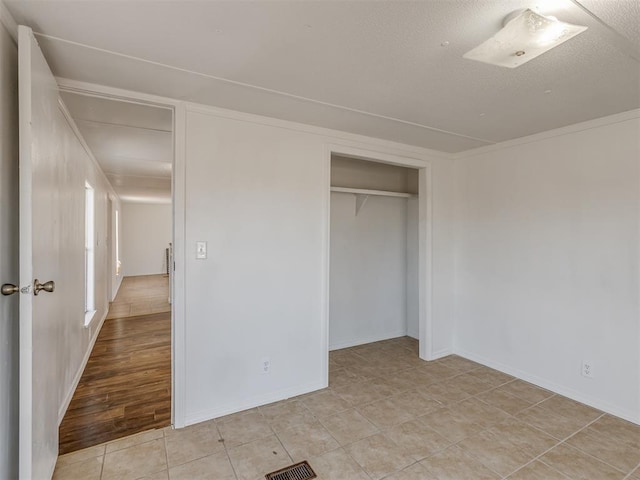 unfurnished bedroom featuring light tile patterned floors and a closet