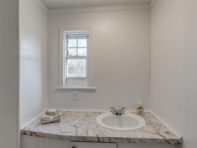 bathroom featuring ornamental molding and sink