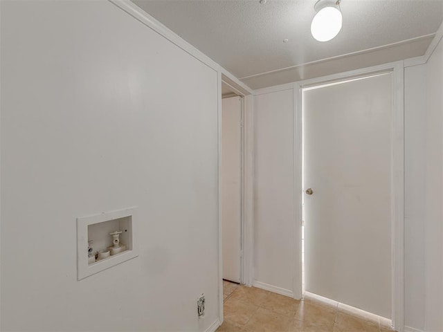 clothes washing area featuring hookup for a washing machine, light tile patterned floors, laundry area, and a textured ceiling