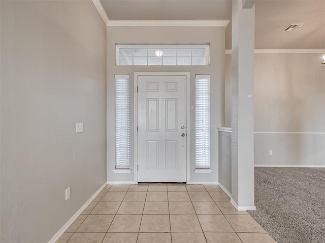 foyer with ornamental molding and light tile patterned floors