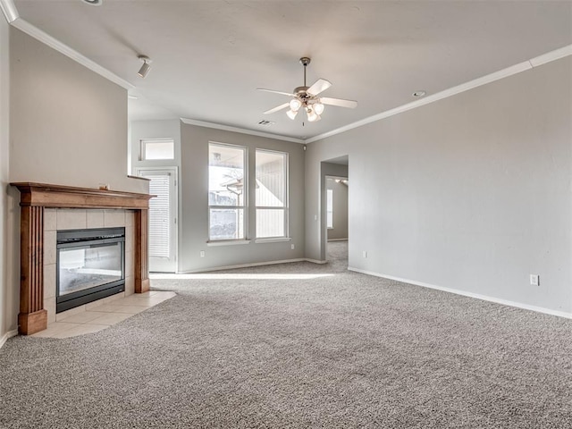 unfurnished living room featuring a fireplace, rail lighting, ornamental molding, light colored carpet, and ceiling fan