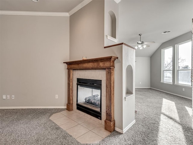 unfurnished living room with lofted ceiling, a tile fireplace, ceiling fan, ornamental molding, and light colored carpet