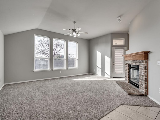 unfurnished living room featuring ceiling fan, light colored carpet, lofted ceiling, and a brick fireplace