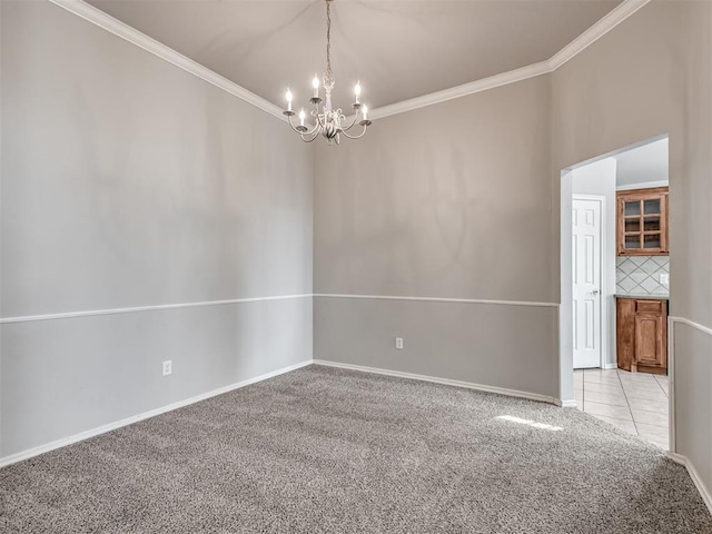 carpeted spare room with ornamental molding and a notable chandelier