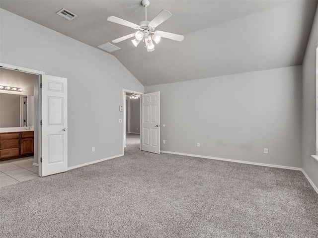 unfurnished bedroom with connected bathroom, vaulted ceiling, light colored carpet, and ceiling fan