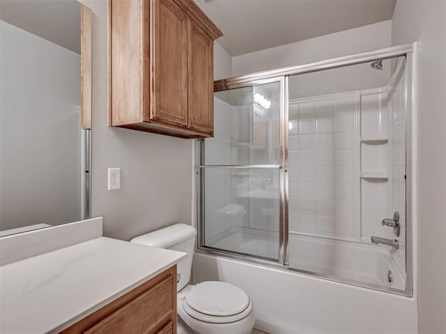 full bathroom featuring vanity, shower / bath combination with glass door, and toilet