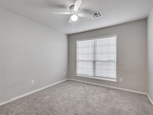 carpeted spare room featuring ceiling fan