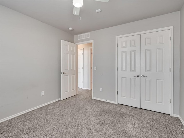 unfurnished bedroom featuring ceiling fan, a closet, and carpet