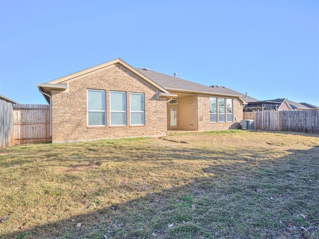 back of house with a yard and central AC unit