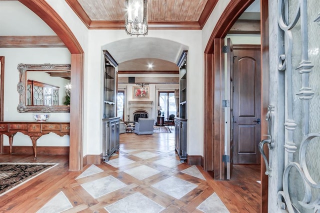 entrance foyer featuring ornamental molding, an inviting chandelier, and light hardwood / wood-style floors