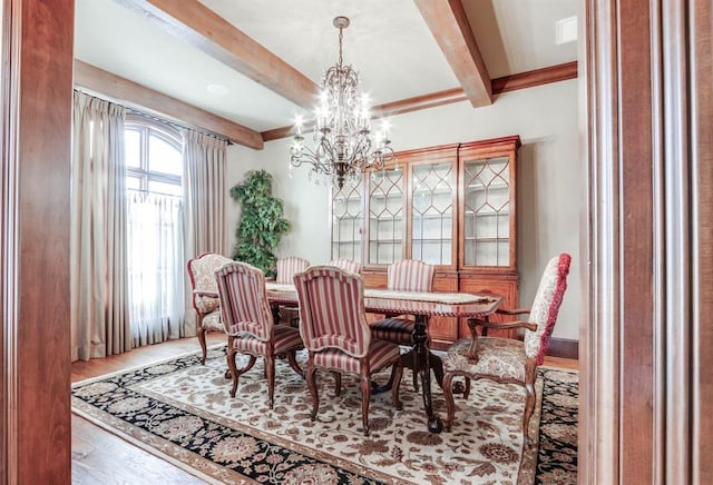 dining area with an inviting chandelier, hardwood / wood-style floors, and beam ceiling