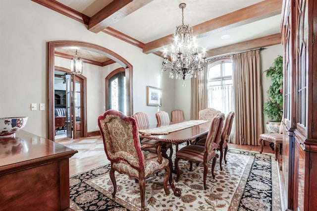 dining space with beamed ceiling, ornamental molding, light wood-type flooring, and a chandelier