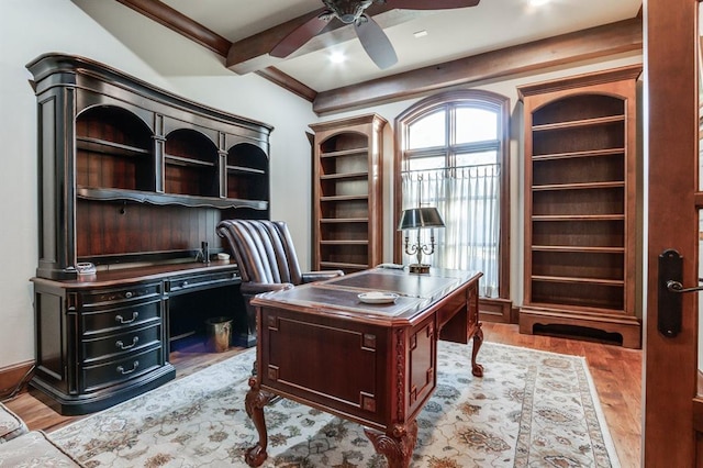 office space featuring beam ceiling, crown molding, ceiling fan, and light hardwood / wood-style flooring