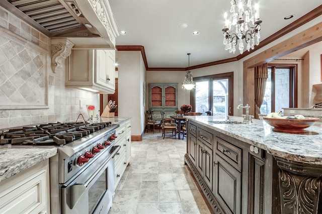 kitchen with decorative light fixtures, sink, high end stainless steel range, light stone counters, and wall chimney range hood