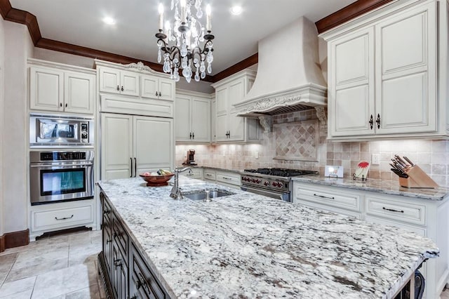 kitchen with sink, premium range hood, stainless steel appliances, white cabinets, and decorative light fixtures