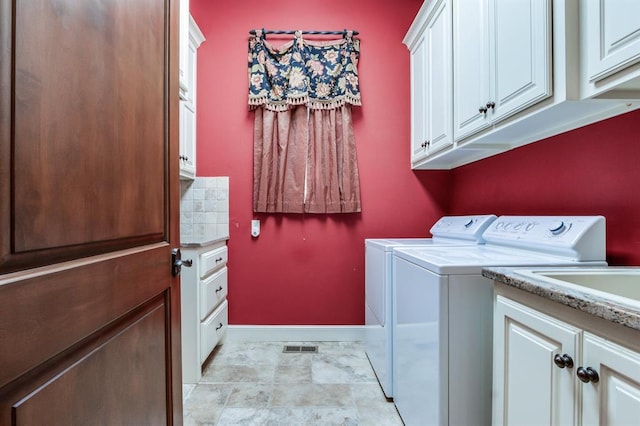 laundry room featuring washing machine and dryer and cabinets