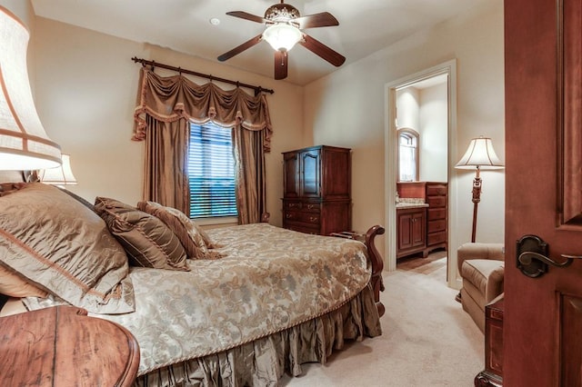 carpeted bedroom with connected bathroom and ceiling fan