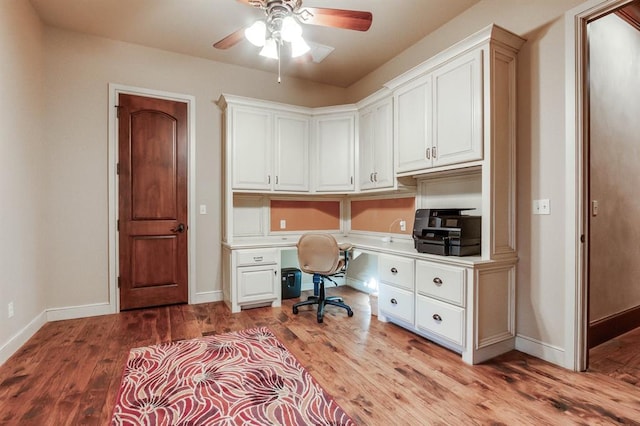 office area featuring ceiling fan, built in desk, and light wood-type flooring