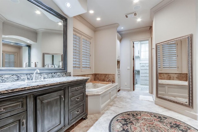 bathroom with ornamental molding, vanity, and a bath