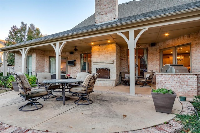 view of patio / terrace with an outdoor stone fireplace and exterior kitchen