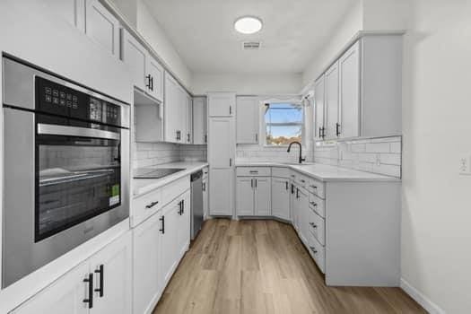 kitchen with white cabinetry, stainless steel appliances, and sink