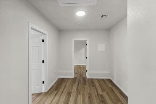 corridor with hardwood / wood-style flooring