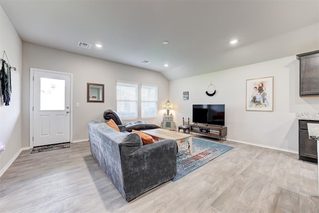 living room featuring vaulted ceiling and light hardwood / wood-style flooring