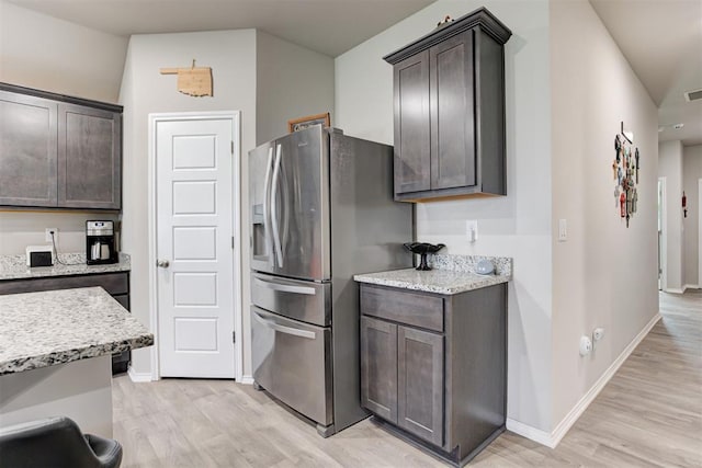 kitchen with stainless steel fridge, light hardwood / wood-style floors, and dark brown cabinets