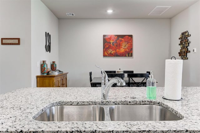 kitchen featuring light stone countertops and sink